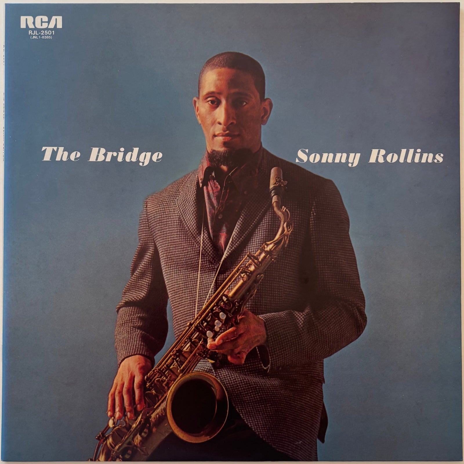 Album cover featuring a man holding a saxophone with 'The Bridge' and 'Sonny Rollins' text on a blue background.