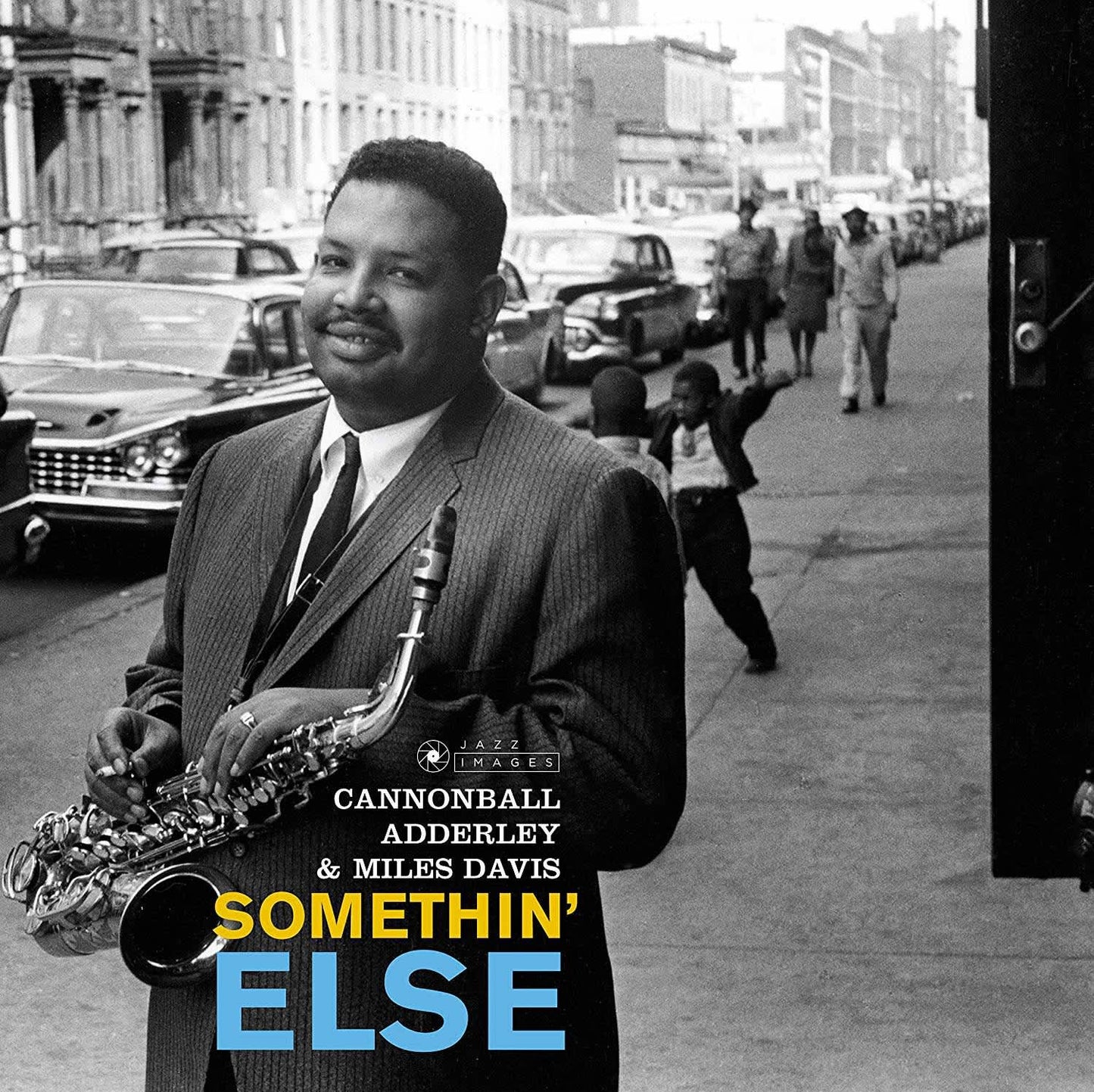 Album cover with a man playing saxophone on a city street, featuring text for Cannonball Adderley and Miles Davis' 'Somethin' Else'.