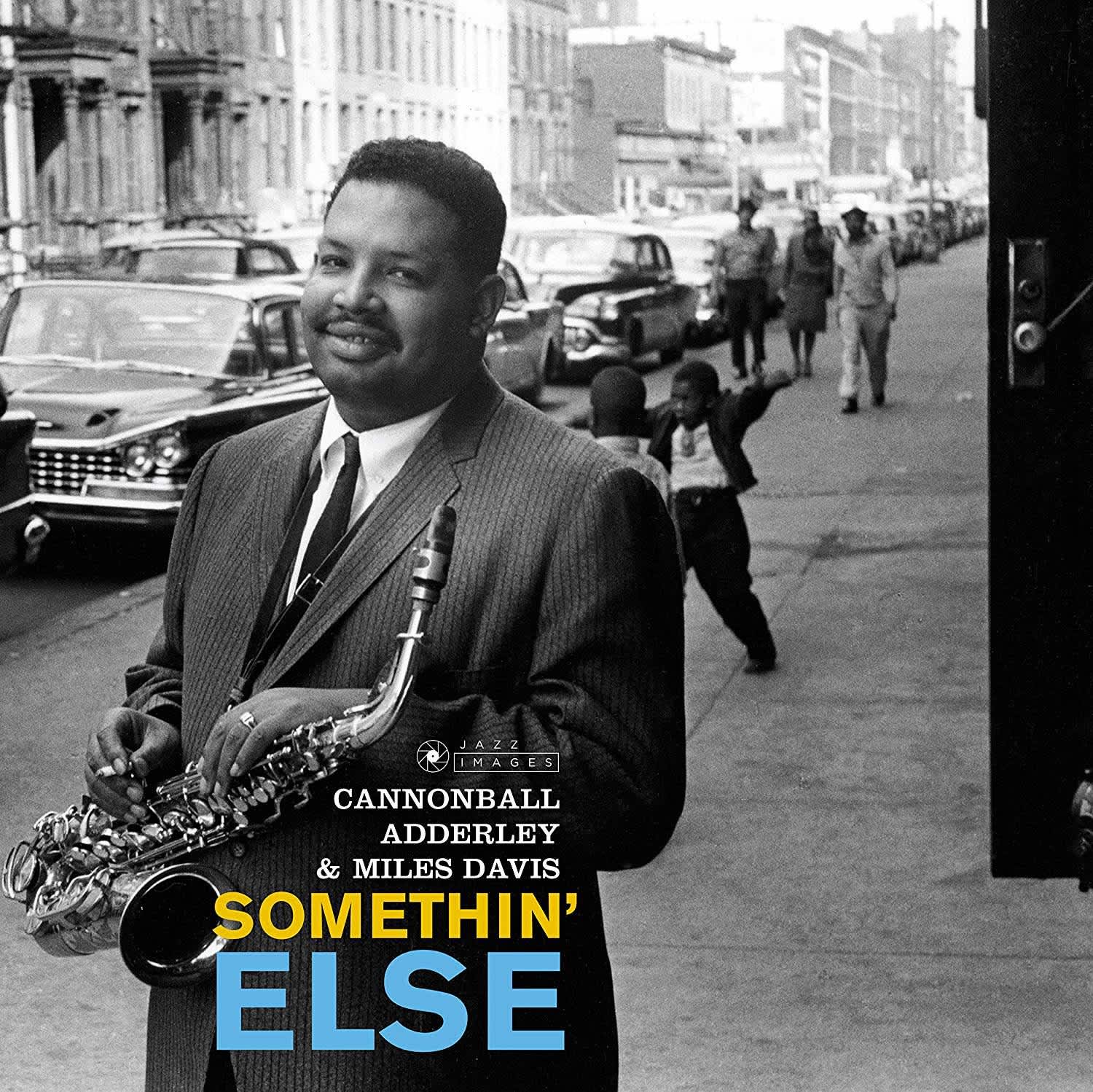 Album cover with a man playing saxophone on a city street, featuring text for Cannonball Adderley and Miles Davis' 'Somethin' Else'.